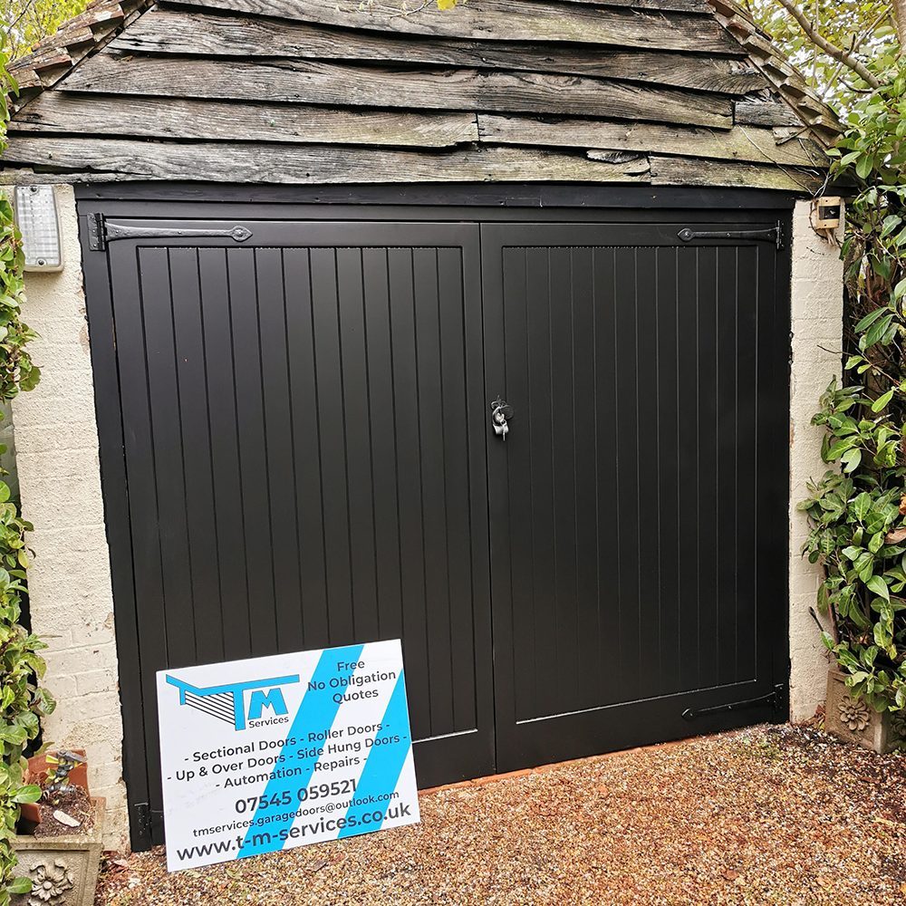 Newly installed black hinged garage door